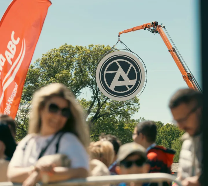 The Amon Productions logo hanging from a crane above the crowd