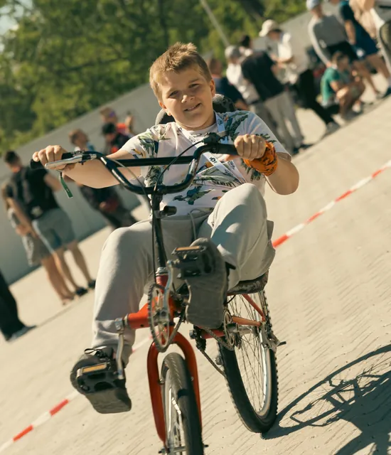 A smiling boy on a modified recumbent bike at the event
