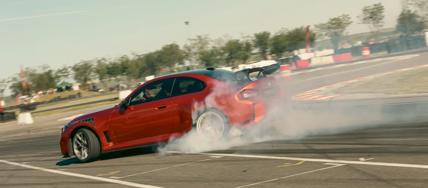 A red BMW drifting with smoking tyres at APX 2026, Black Star Speedway, Visonta