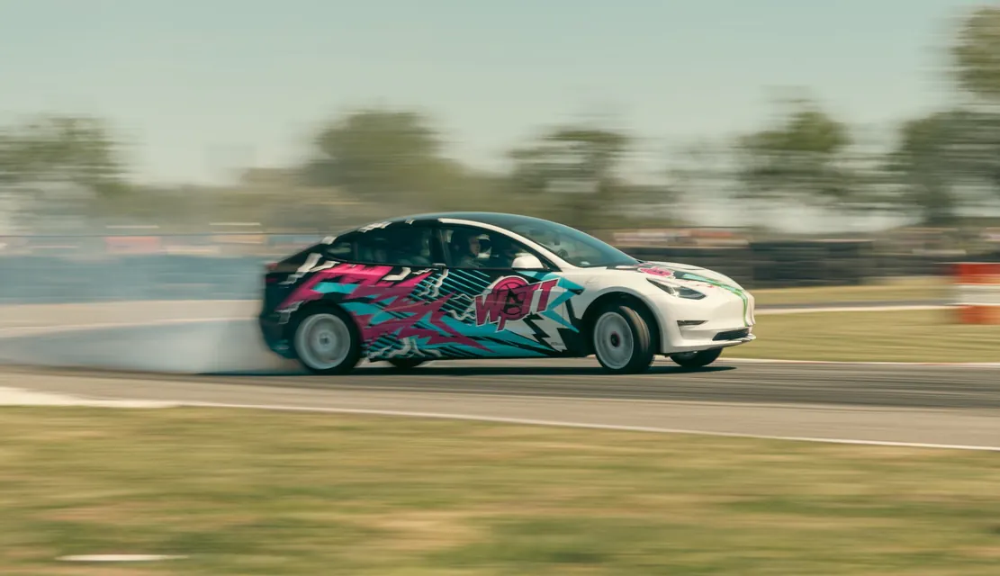 A wrapped Tesla Model 3 drifting, caught in motion