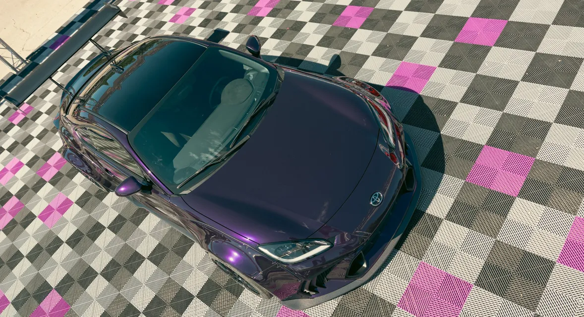 A purple Toyota sports car from above on a chequered floor