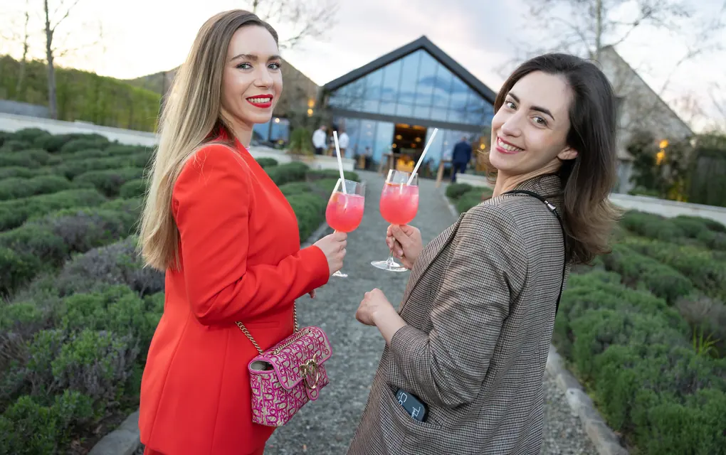 Két vendég koktéllal egy szabadtéri rendezvény fogadásán