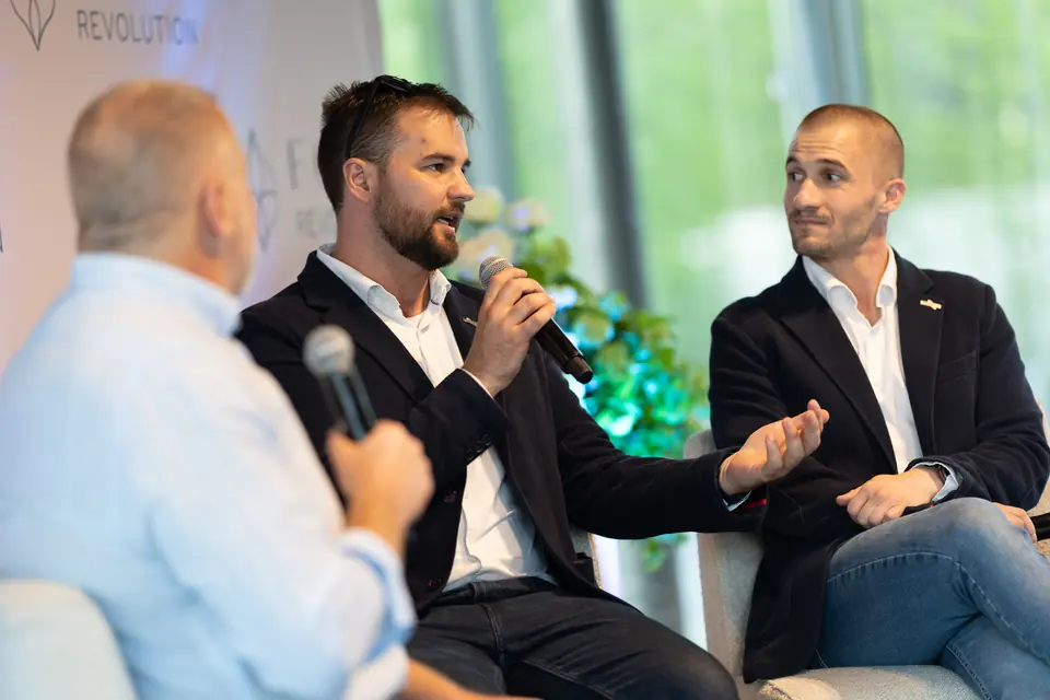 Panelbeszélgetés három résztvevővel egy konferencia színpadán