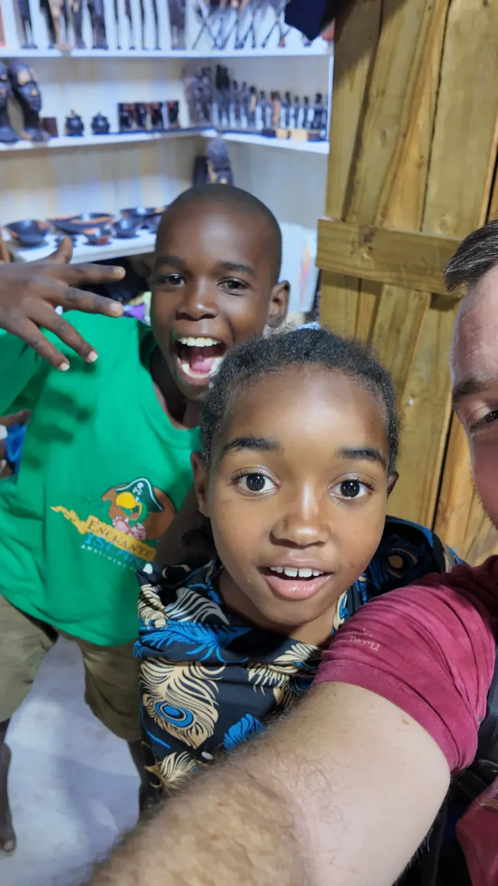 Dávid’s selfie with two laughing children in a shop full of wood carvings