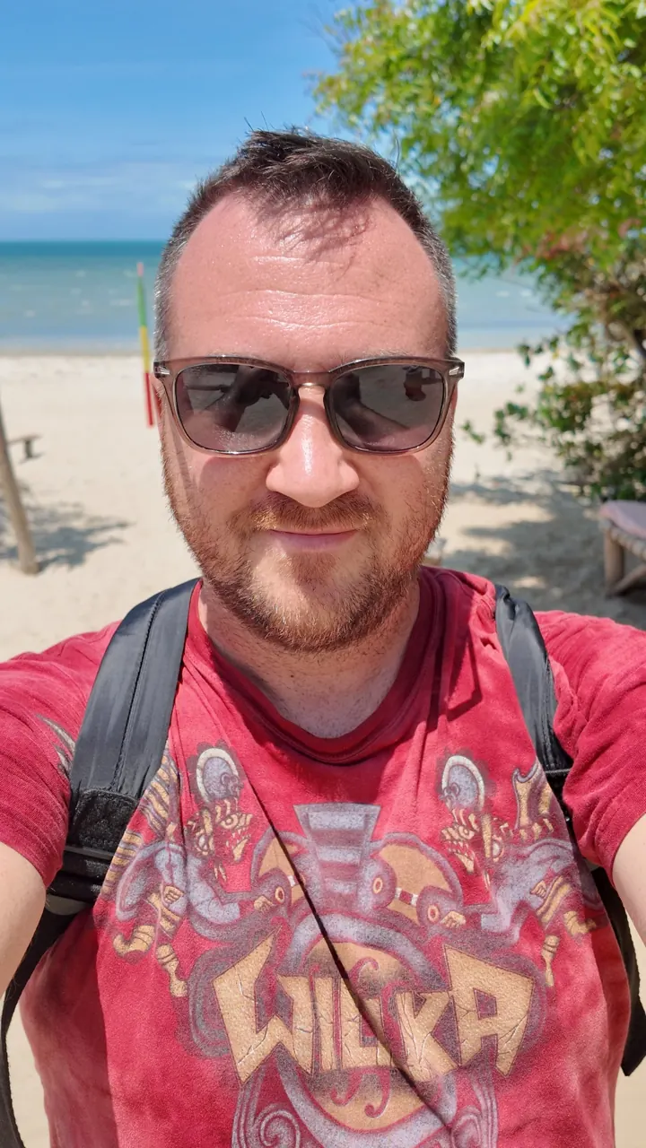 Dávid Egerváry in sunglasses with a backpack on the beach