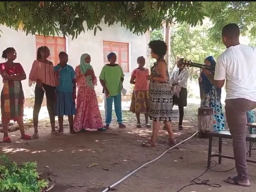 Outdoor music session in the shade of a tree in Tanzania, with guitar