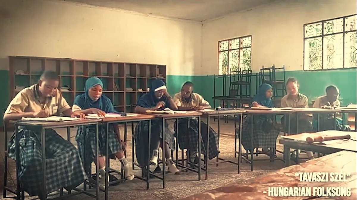 Students in uniform at their desks in a Tanzanian classroom, with the caption Tavaszi szél, Hungarian folksong